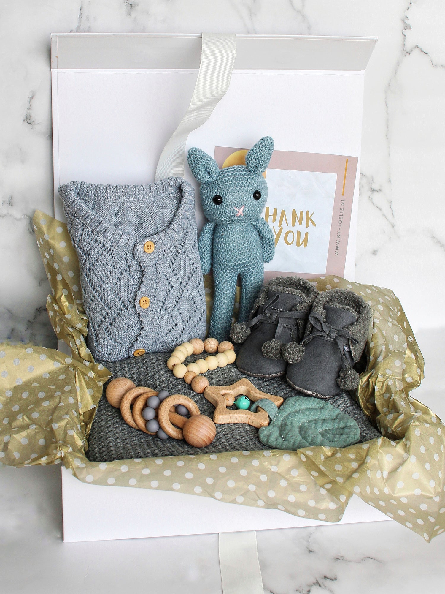 Luxe giftbox van by-joelle.nl guvuld met gebreiden knuffel, zachte slofjes, rammelaar en gebreide deken.